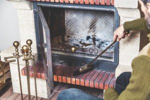 Man sweeping the hearth to maintain chimney safety